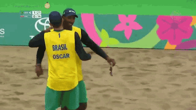 two volleyball players from brazil are hugging each other in front of a toyota sign