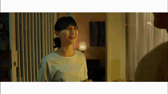 a woman is smiling while standing next to a man in a living room