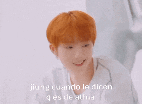 a young man with orange hair is smiling with the words jiung cuando le dicen q es de athia above him
