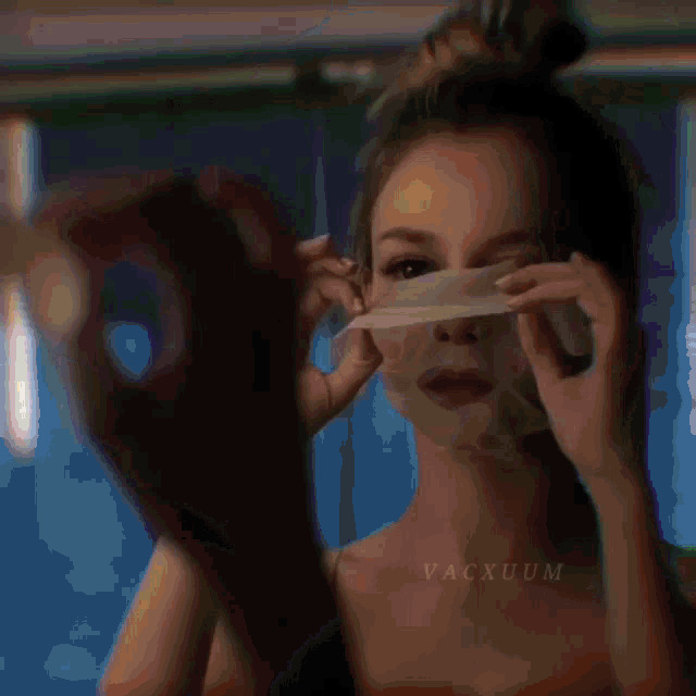 a woman is standing in a dark room with the word vacuum written on her chest