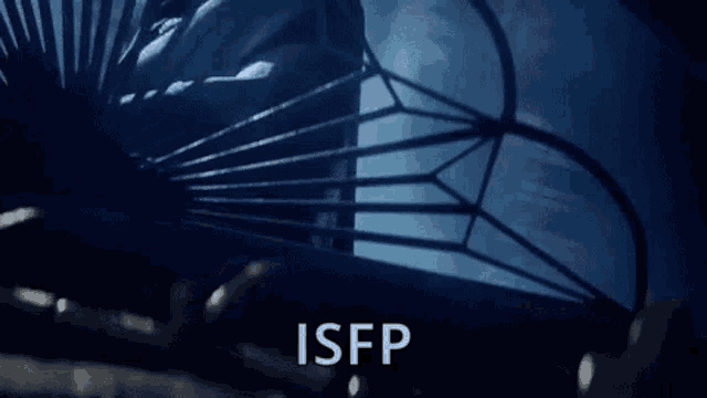 a man in a suit and tie is behind a metal cage with the word isfp written on the bottom .
