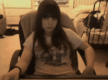 a girl is sitting in a chair wearing a shirt that says ' avengers '