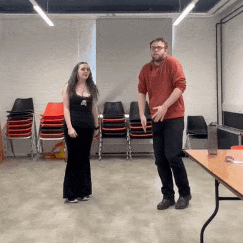 a man and a woman are standing next to each other in a room