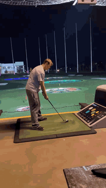 a man is swinging a golf club at a golf course