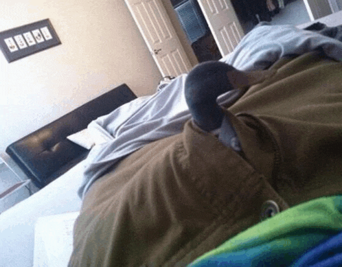 a person is laying on a bed with a picture on the wall that says ' i love you '