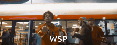 a group of people are dancing in front of a bus and the word wsp is written on the screen .