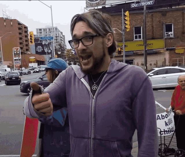 a man in a purple jacket is pointing at something
