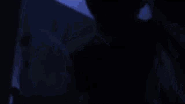 a person in a dark room with a blue background
