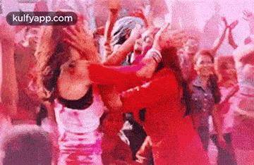 a group of people are dancing in a room with pink powder .