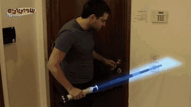 a man is holding a light saber in front of a sign that says ' switzerland ' on it