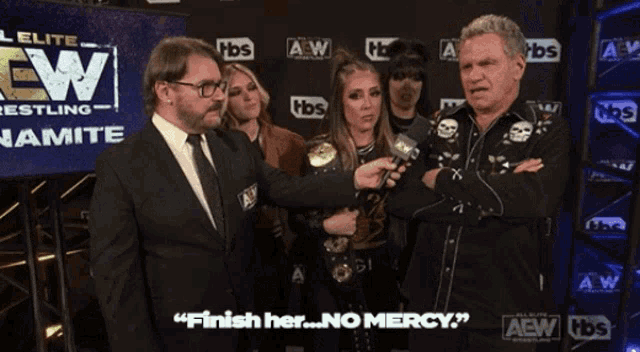 a group of people standing in front of a screen that says aew