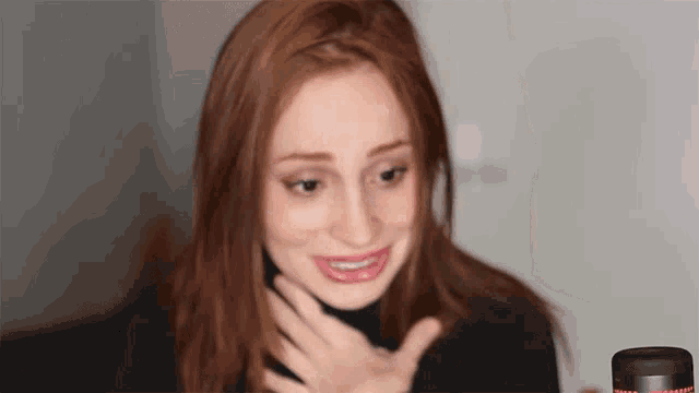 a woman with red hair is making a face in front of a microphone