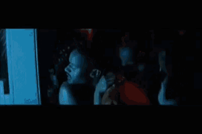 a man is holding a woman 's arm in the dark .