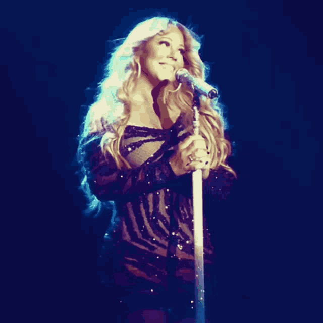 a woman singing into a microphone on stage