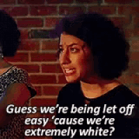a woman is talking to another woman in front of a brick wall and says `` guess we 're being let off easy ''