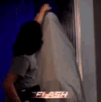 a woman is standing in front of a window with a ghost hanging from the wall .
