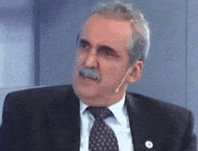 a man wearing a suit and tie with a microphone in his ear