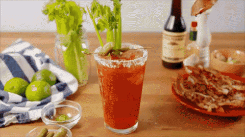 a bloody mary is being poured into a glass with celery on a toothpick