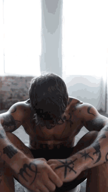 a shirtless man with a tattoo on his arm that says " m "