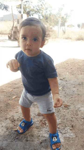 a young boy wearing blue mickey mouse sandals
