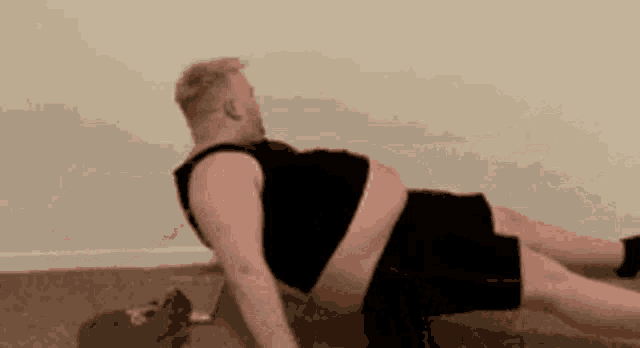 a man with a very large belly is doing push ups on the floor in a room .