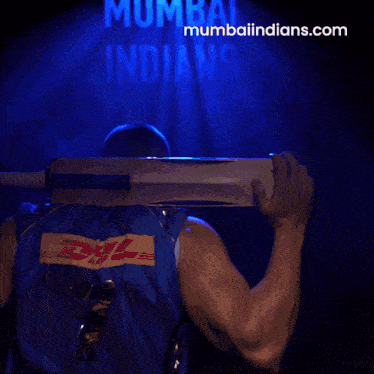 a man holding a cricket bat in front of a blue background that says mumbai indians