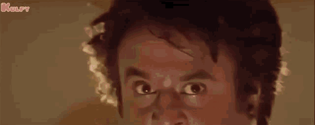 a close up of a man 's face with his eyes wide open .