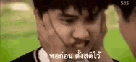 a close up of a person 's face with a hand on it in a foreign language .