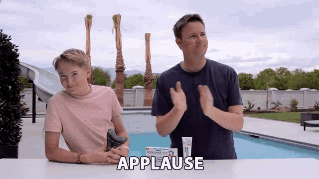 a man and a boy are clapping in front of a tube of sensodyne