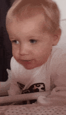 a baby is wearing a white shirt with a leopard print