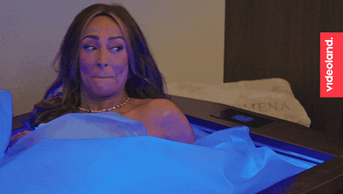 a woman laying in a bed with a videoland logo