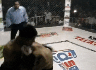 two men are fighting in a boxing ring with a tecate logo on the floor .
