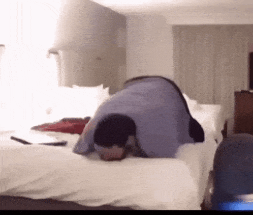 a man is laying on his back on a bed in a hotel room