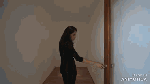a woman is opening a door with the words made in animatica on the bottom
