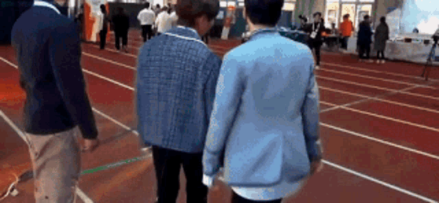 a group of people are standing on a track .