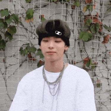 a young man wearing a white shirt and a black headband with an infinity symbol