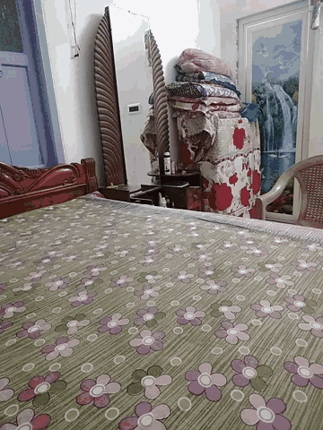 a bedroom with a bed and a chair and a floral wallpaper