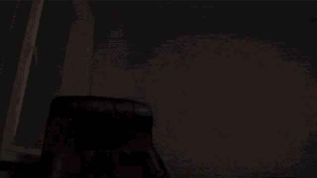 a black leather chair is sitting in front of a window in a room