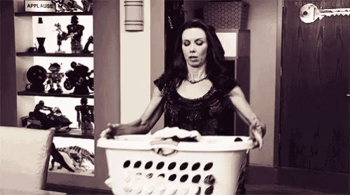 a woman is holding a laundry basket full of clothes .