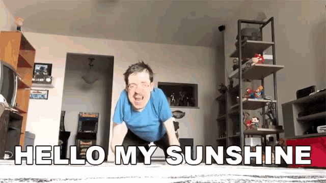 a man in a blue shirt is doing push ups in a living room with the words hello my sunshine below him