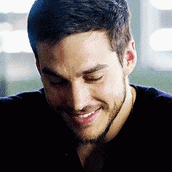 a close up of a man 's face with a beard smiling .