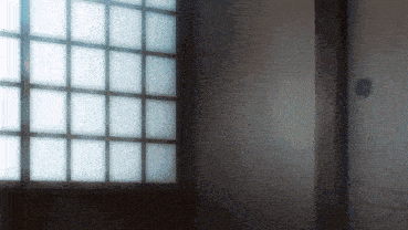 a dark room with a sliding door and a window