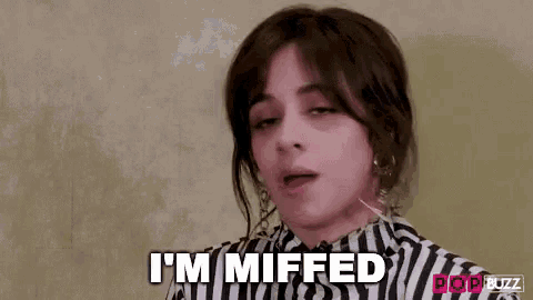 a woman in a striped shirt is making a funny face and says `` i 'm miffed '' .