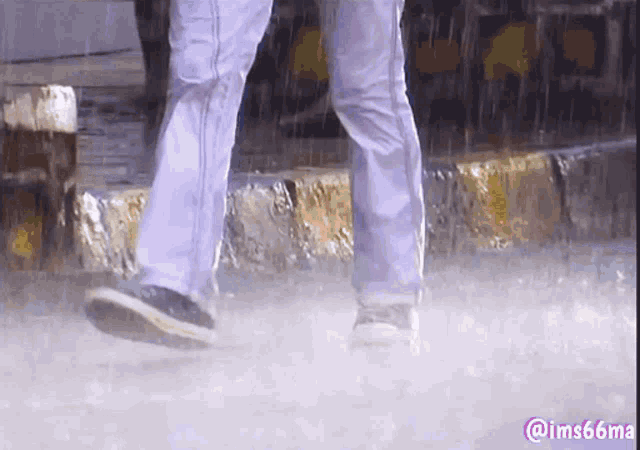a person is walking in the rain with a watermark that says @ ims66ma
