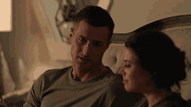 a man in a green shirt sits next to a woman