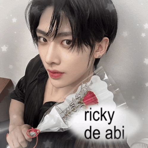 a young man is holding a bouquet of flowers with the name ricky de abi written on the bottom