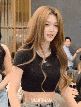 a woman wearing a black crop top with the word wavchan on the bottom