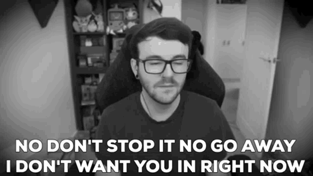 a man with glasses is sitting in a chair and says no don 't stop