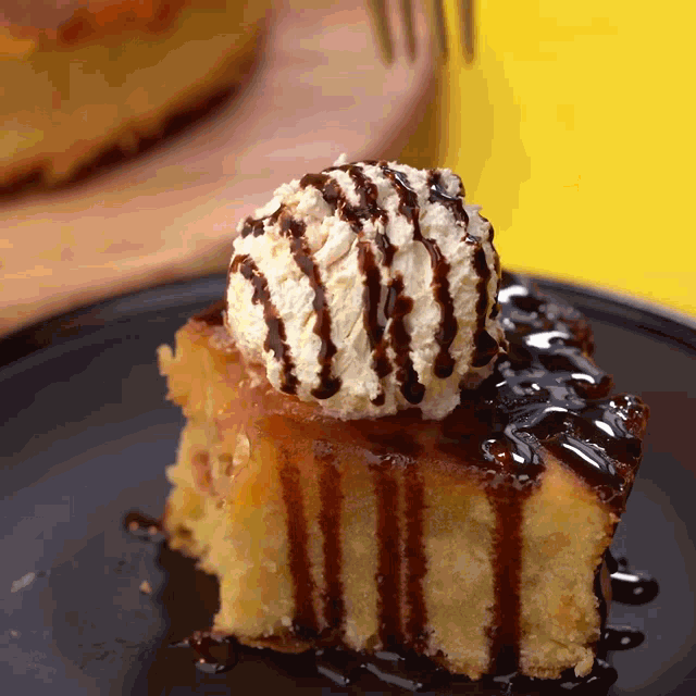 a piece of cake with whipped cream on top and chocolate sauce