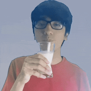 a man wearing glasses is drinking milk from a glass